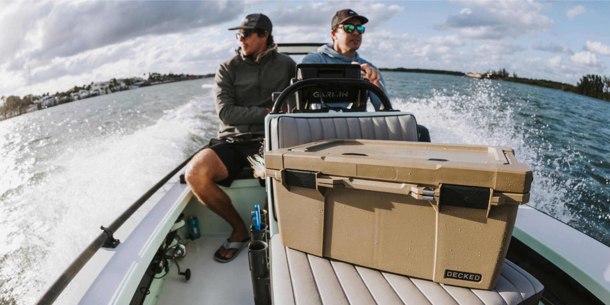 Two men headed out to fish in their boat, in front of them sits a Desert Tan Sixer D-co Case that carries all of their tackle for the day.