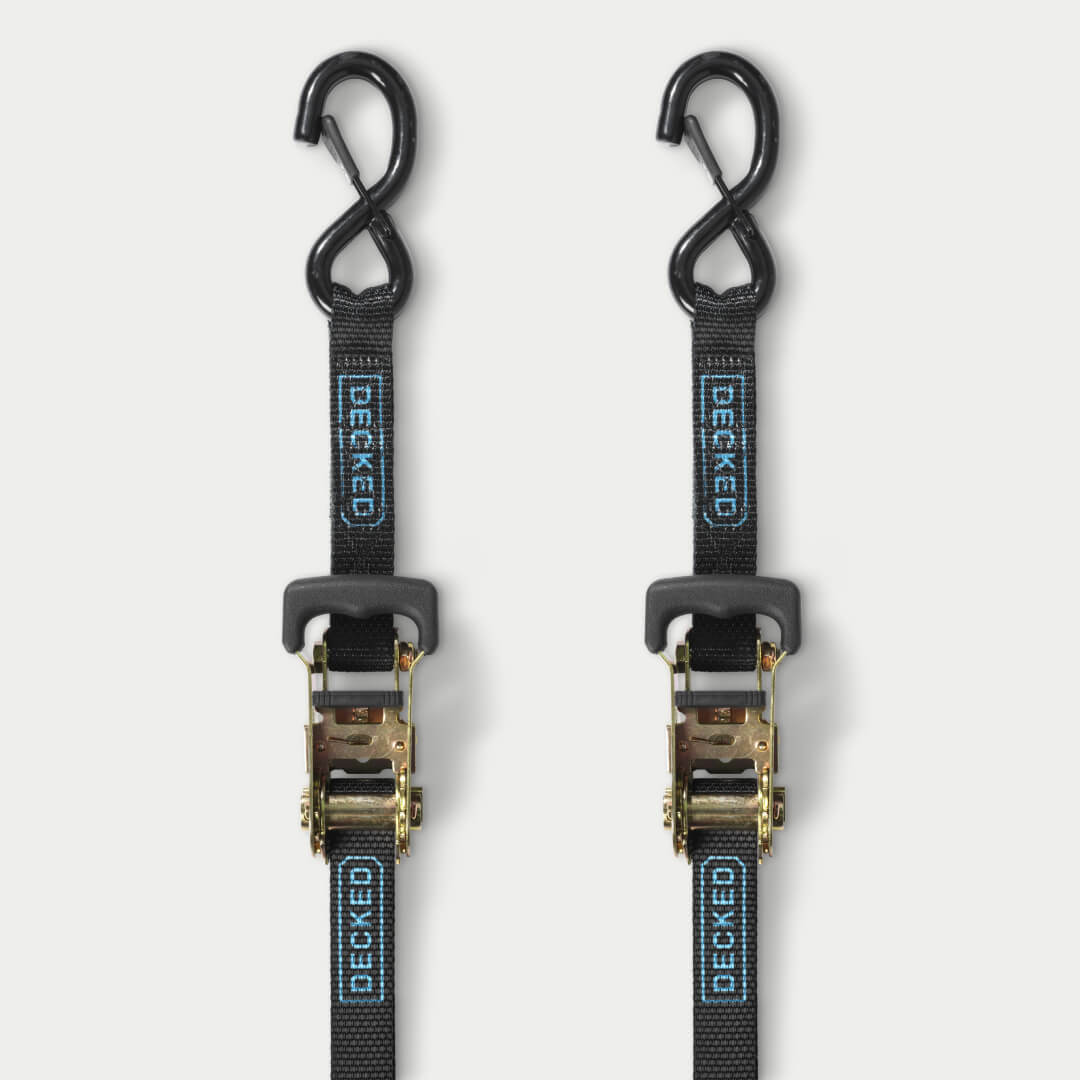 Two black ratchet straps on grey background
