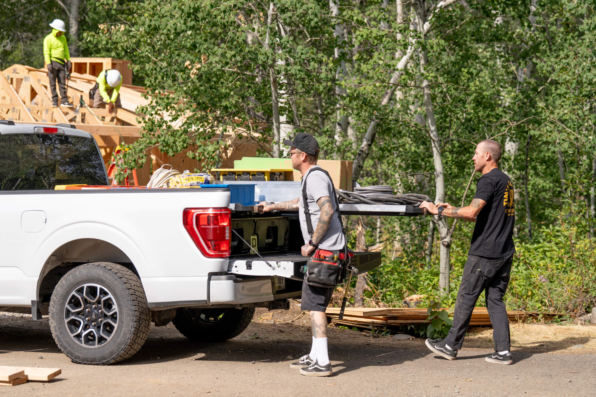 Two electricians retrieving tools from dual-mounted CargoGlides for Drawer System.