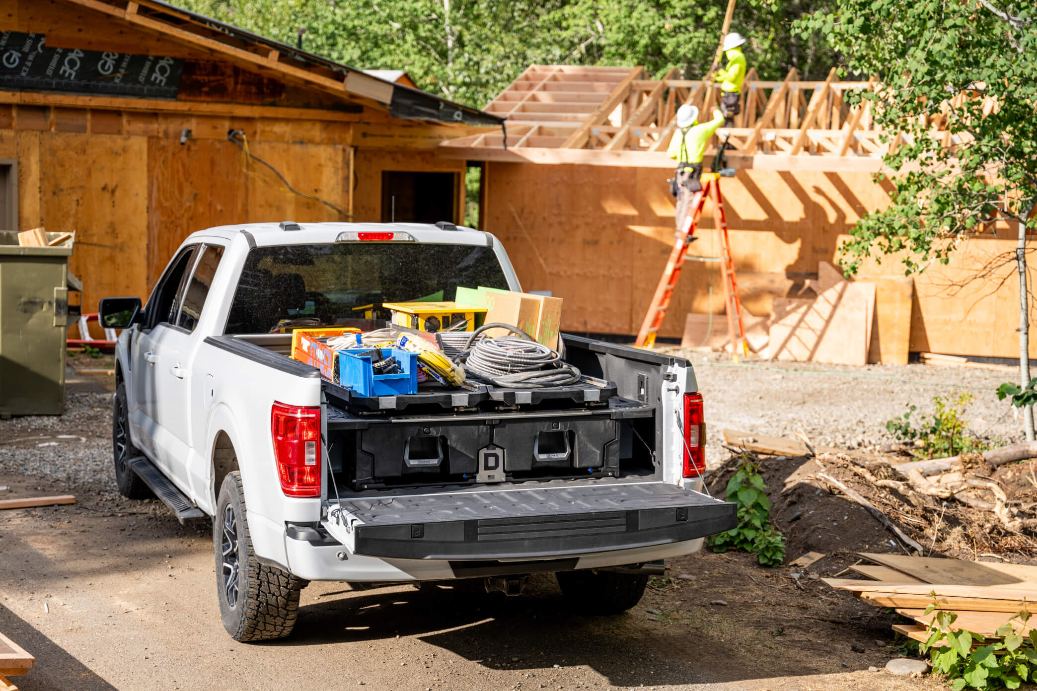 Two CargoGlide 600s mounted on top of a full-size Drawer System piled with electrical and construction equipment at a jobsite.