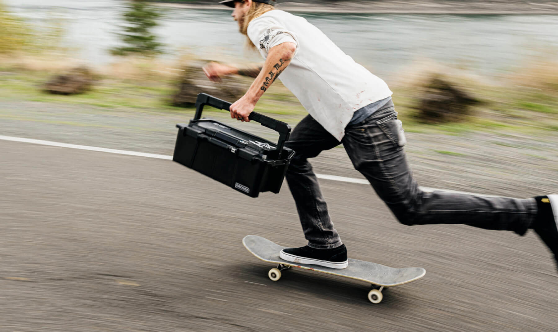 DECKED ambassador, David Gravette, holding tight to his Black Sixer D-co Case while flying down the street on his skateboard.