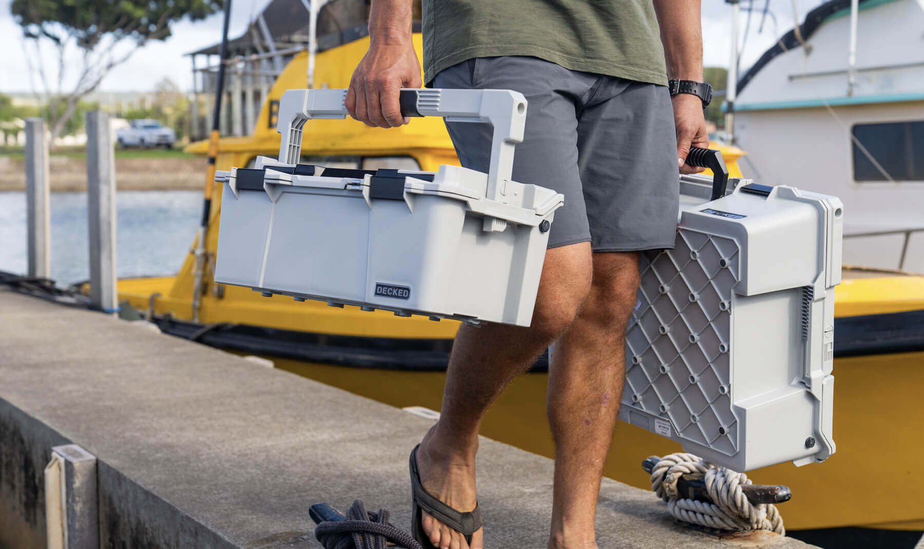 A man walking off the dock in a marina, carrying the Cool Gray Sixer D-co Case which stayed cool to the touch even after sitting in the sun all day.