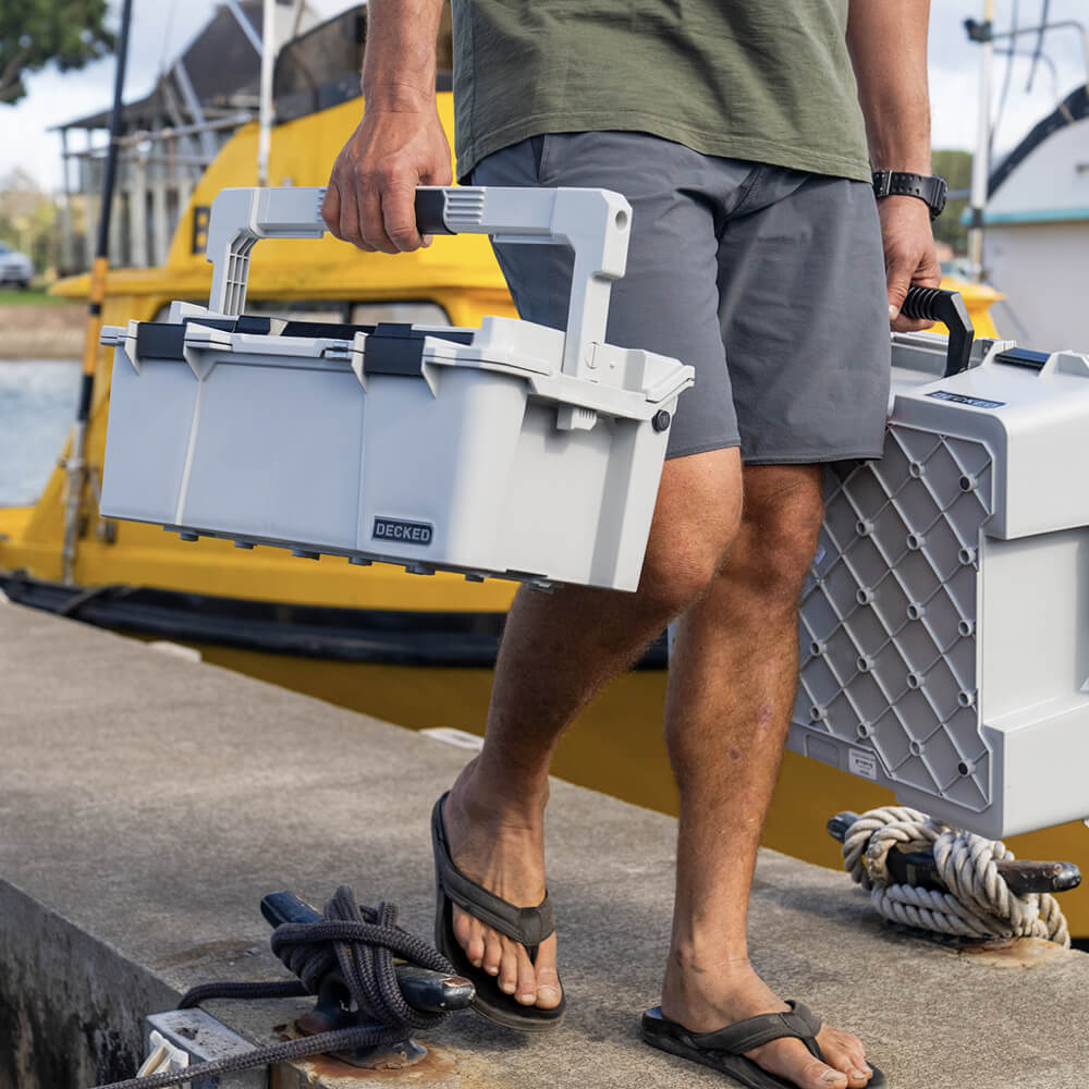 A man walking off the dock in a marina, carrying the Cool Gray Sixer D-co Case which stayed cool to the touch even after sitting in the sun all day.