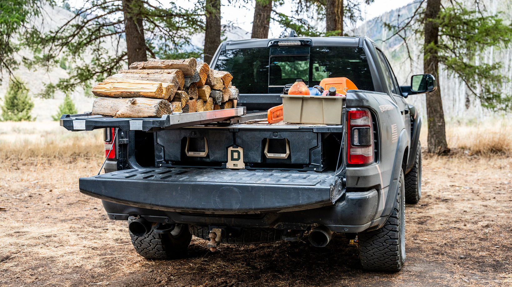 Firewood and timber equipment loaded on a DECKED Drawer System and CargoGlide in a pickup truck bed.