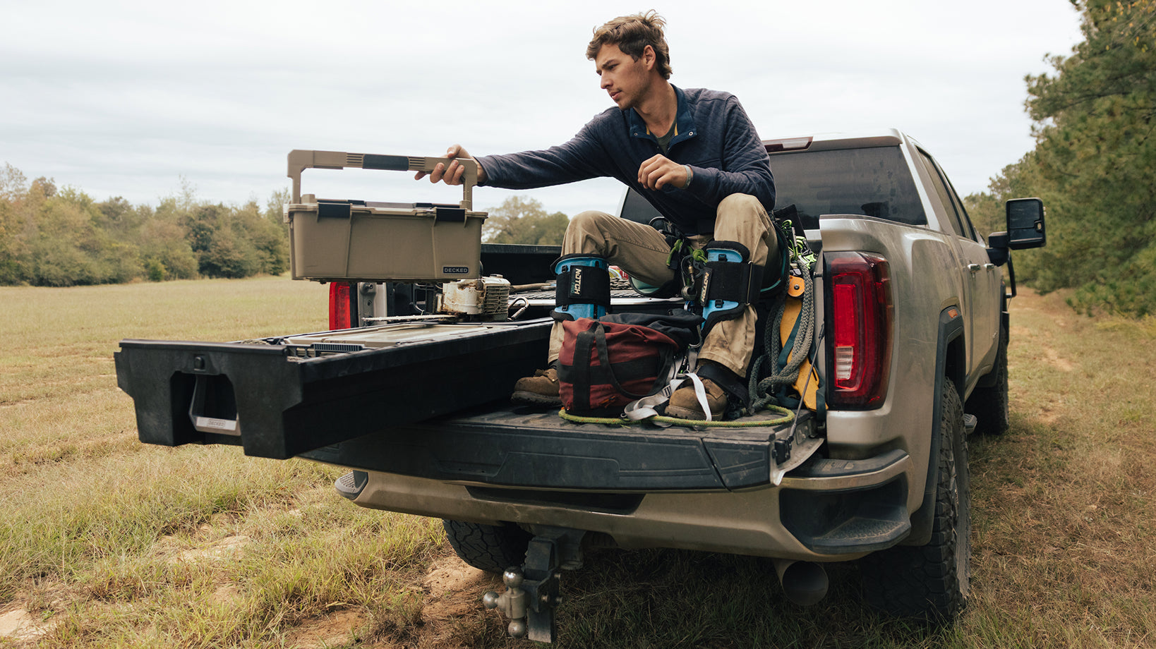Timber worker accessing a DECKED sixer case from an open Drawer System beside climbing gear.