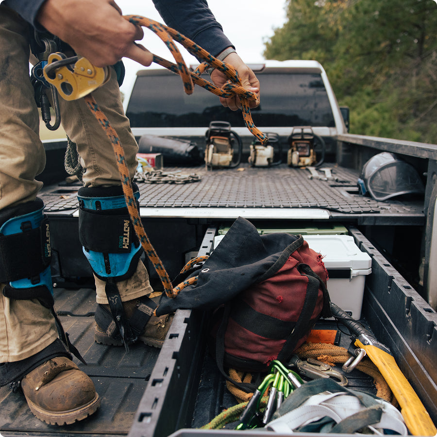 Timber worker retrieving climbing rope and safety gear from a DECKED Drawer System.