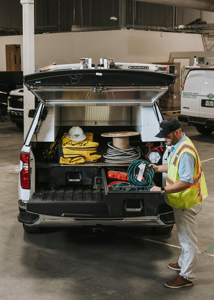 Electrician accessing cables from a DECKED Drawer System in a work truck.