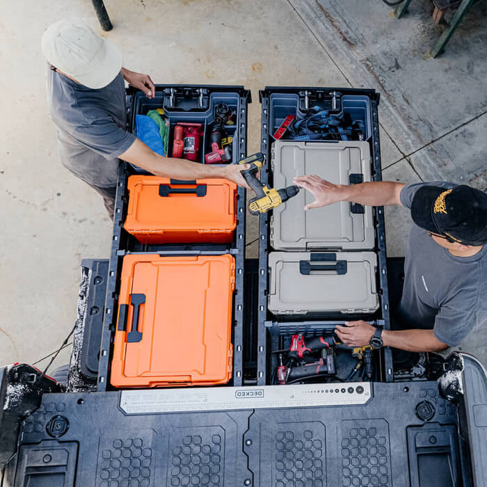 Two people organizing toolboxes in a DECKED Drawer System.