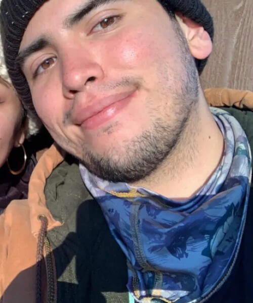 Arturo smiling in a beanie.