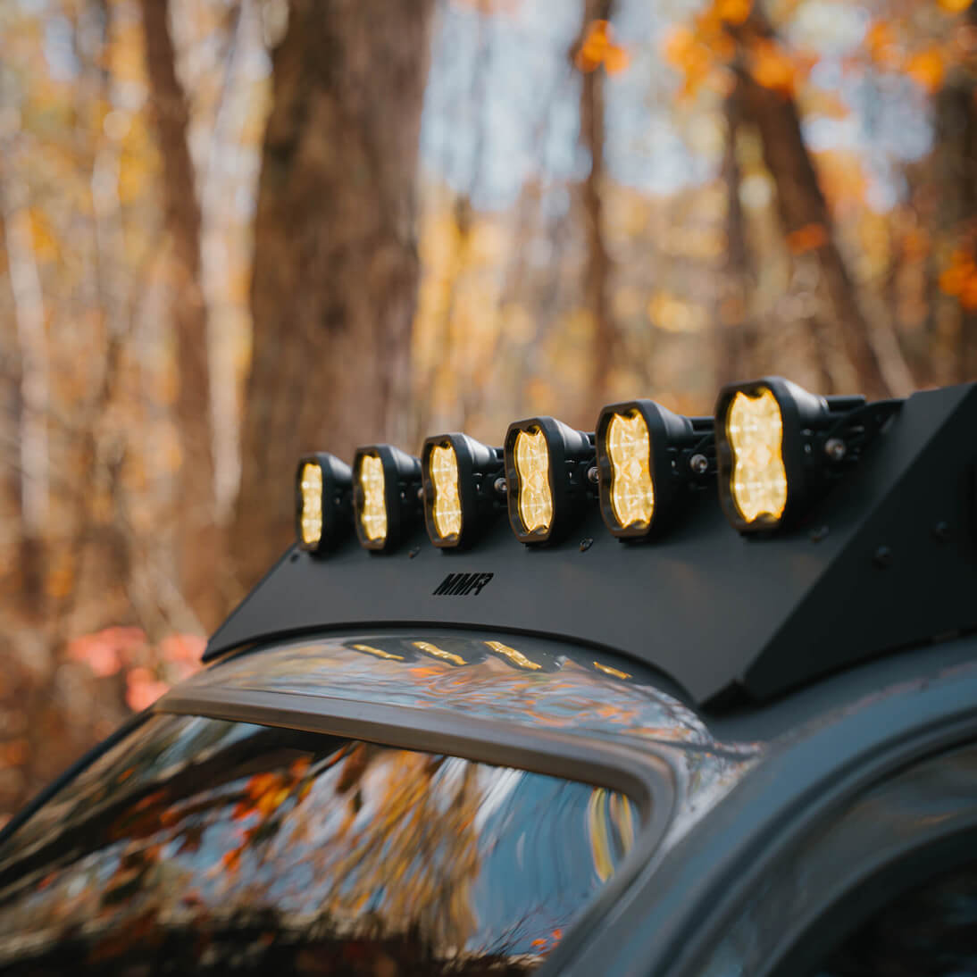 Roof-mounted light bar on a vehicle with a forest background