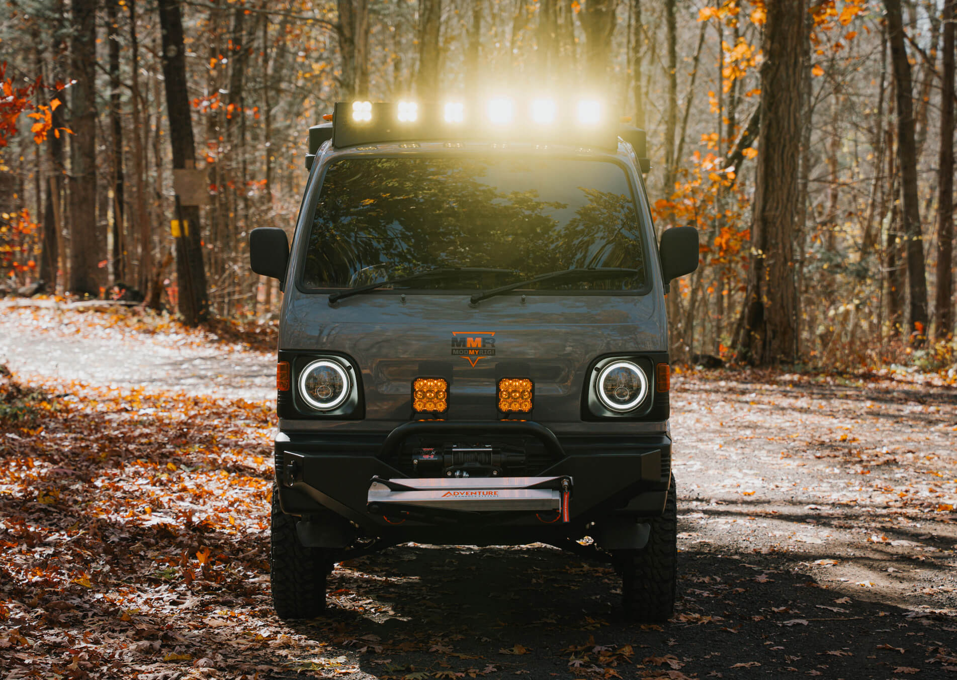 Off-road vehicle with additional lights on a forest path