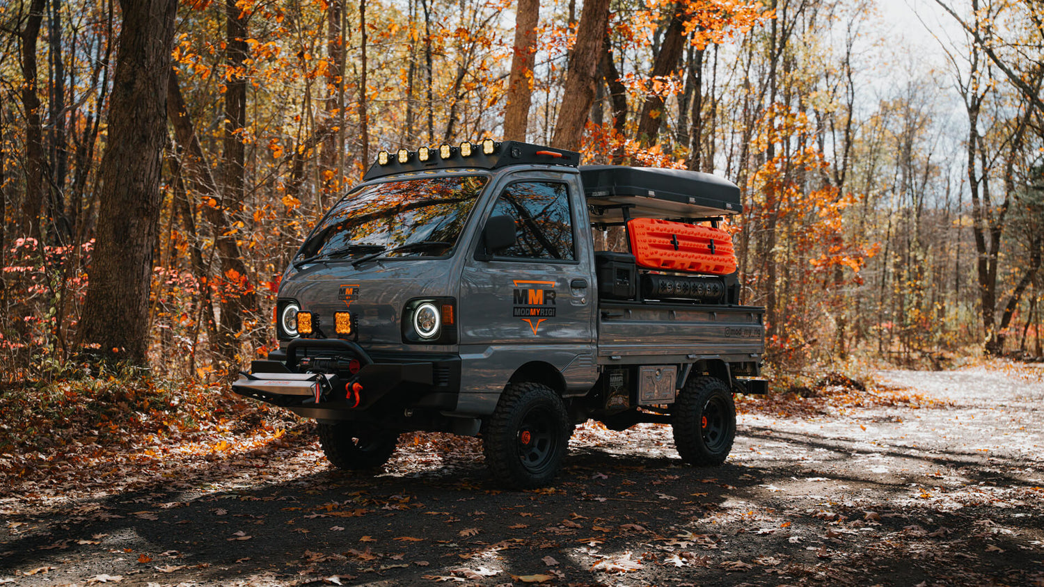 Small truck in a forest with autumn foliage