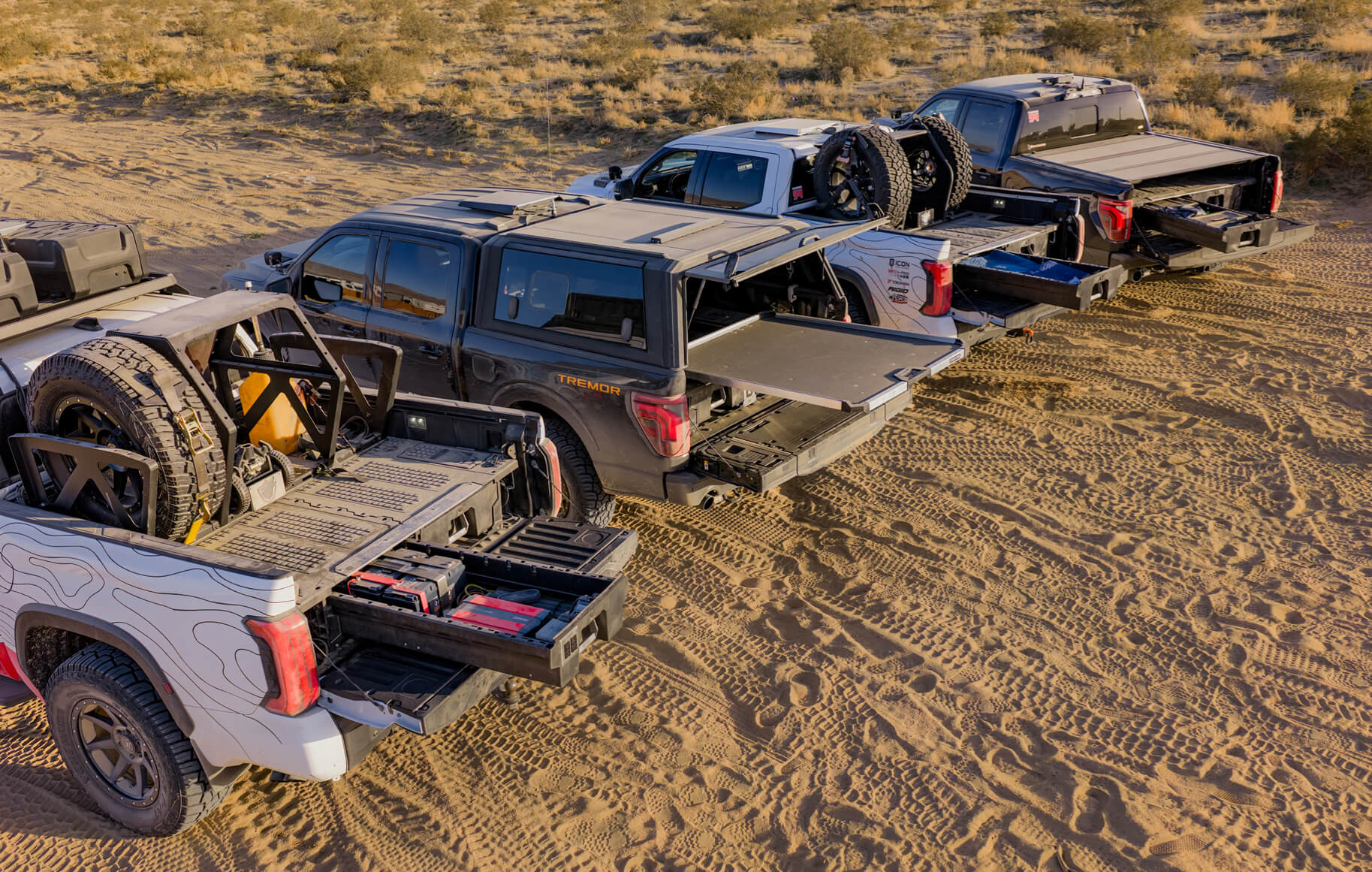 The extended DECKED Drawers and CargoGlide in the back of the Optima fleet trucks, showing spare batteries and other recovery gear needed in the desert.