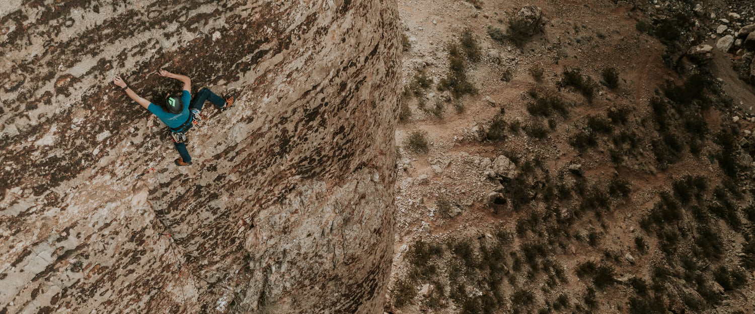 Jackson climbing up a rock face in the desert.