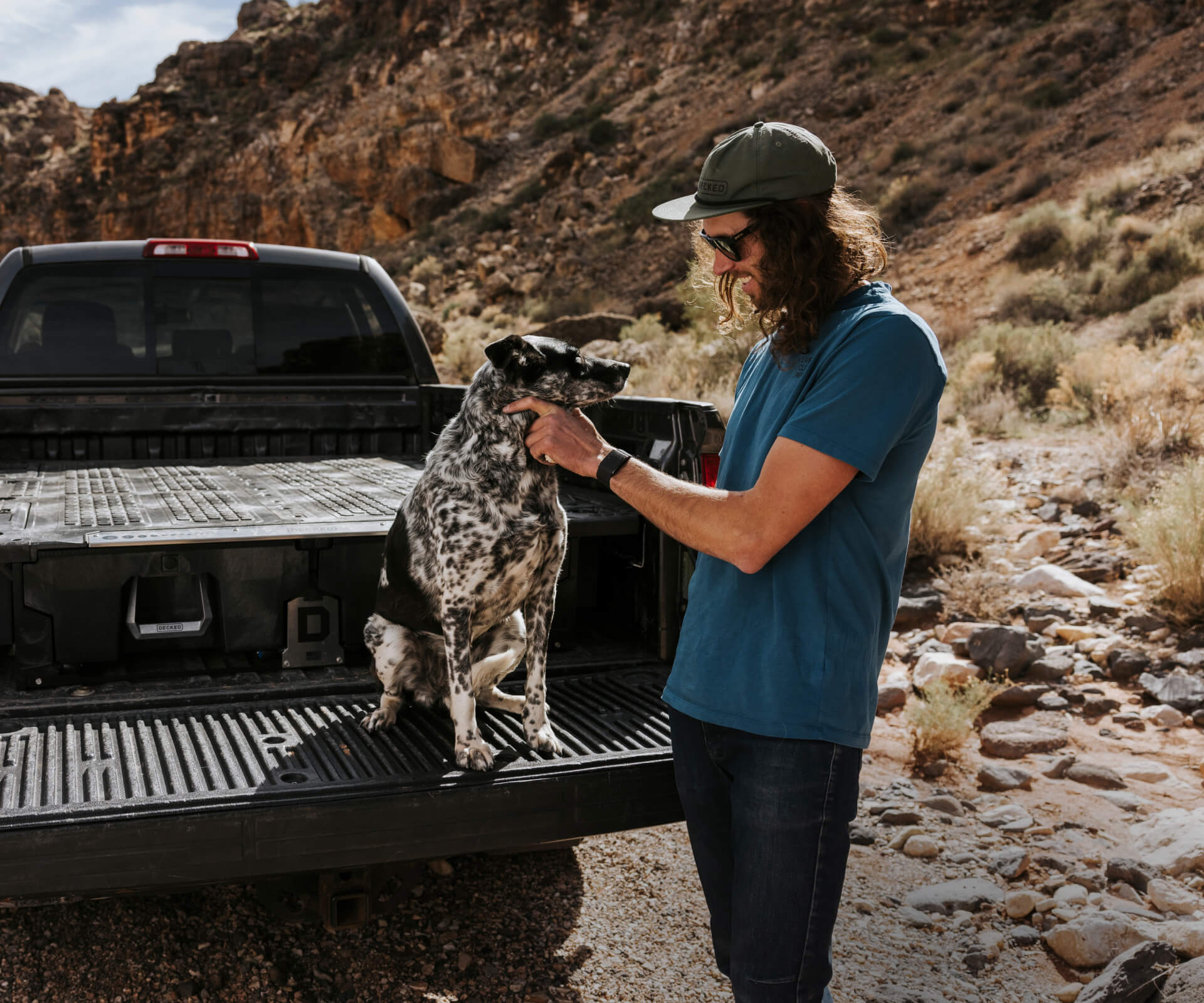 Jackson petting his dog on the tailgate of his truck.