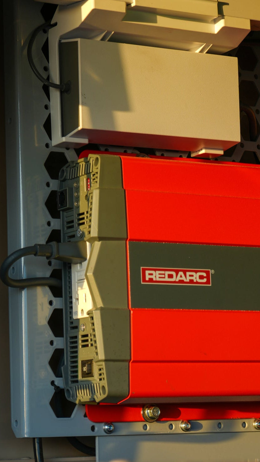 REDARC onboard power system mounted inside a truck canopy for managing batteries, charging, and vehicle electrical accessories.