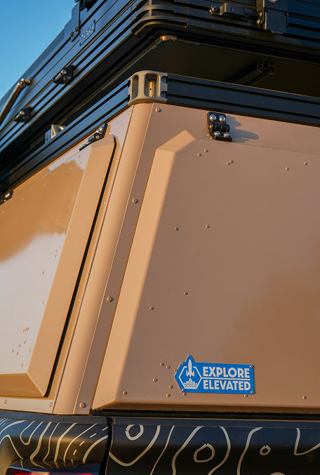 Truck cap with a blue "Explore Elevated" sticker on it.