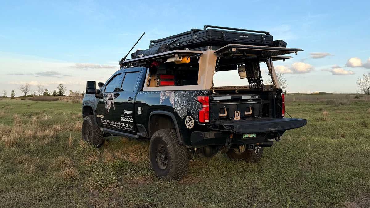 Black overlanding truck with DECKED drawer system and cargoglide mounted inside.