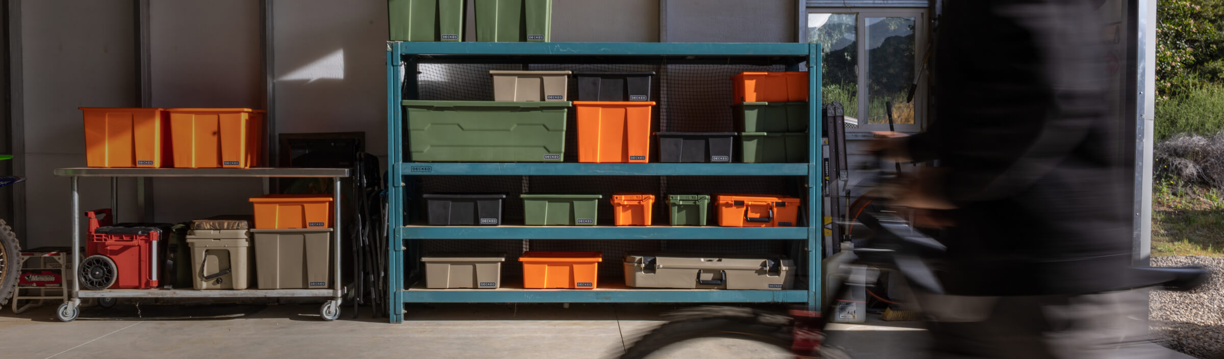 Storage rack with various sizes and colors of bins and cases in a garage setting