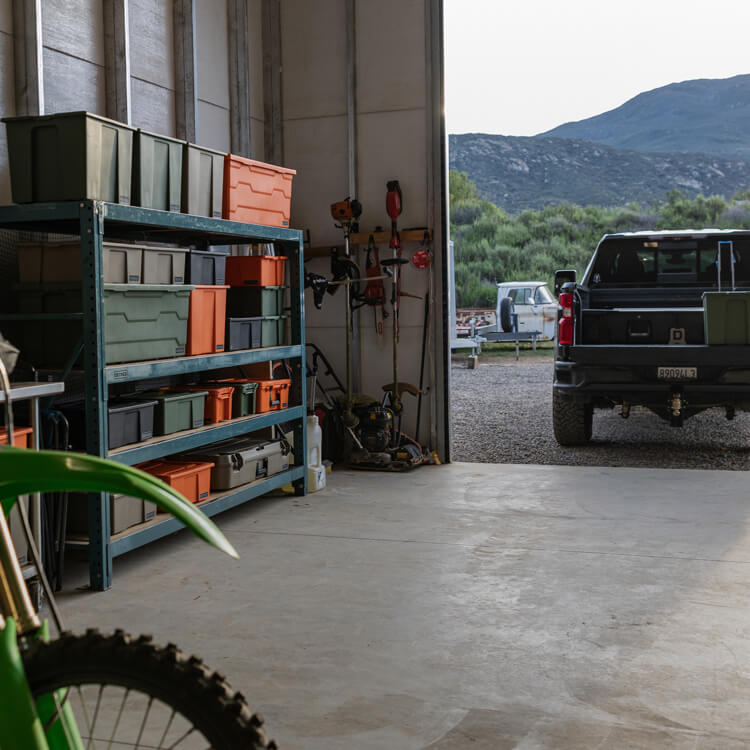 Garage with tools, storage shelves, and a motorcycle.