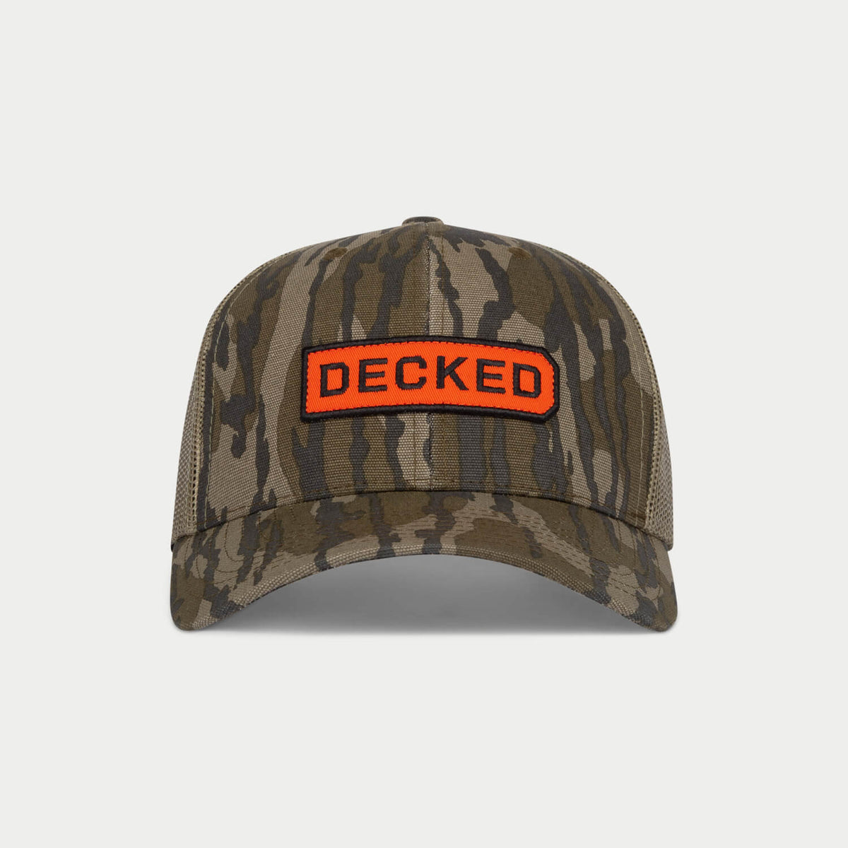 [H0777-LOGO-CAMO] Front view of a Mossy Oak Bottomland camo trucker hat with mesh back and an orange DECKED patch.