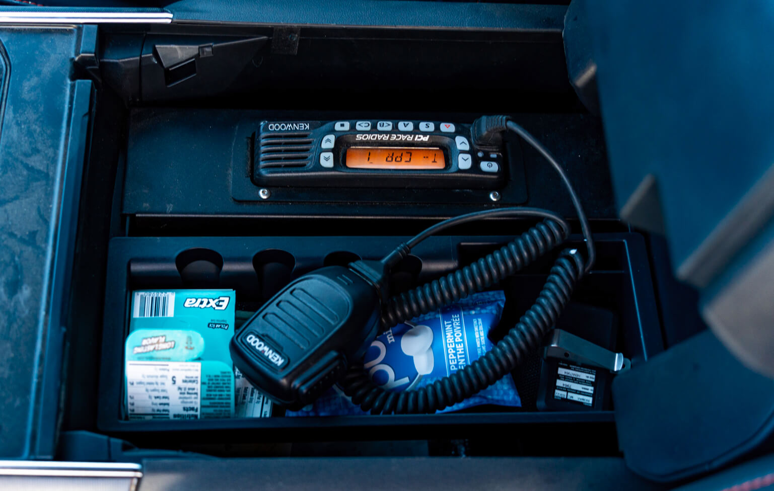 Close-up of a radio communication device with battery and connectors inside a vehicle.