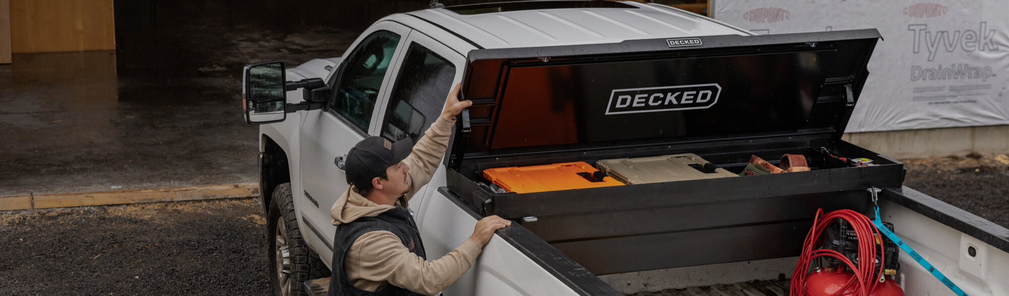 Worker opening a black toolbox containing D-CO cases and other accessories.