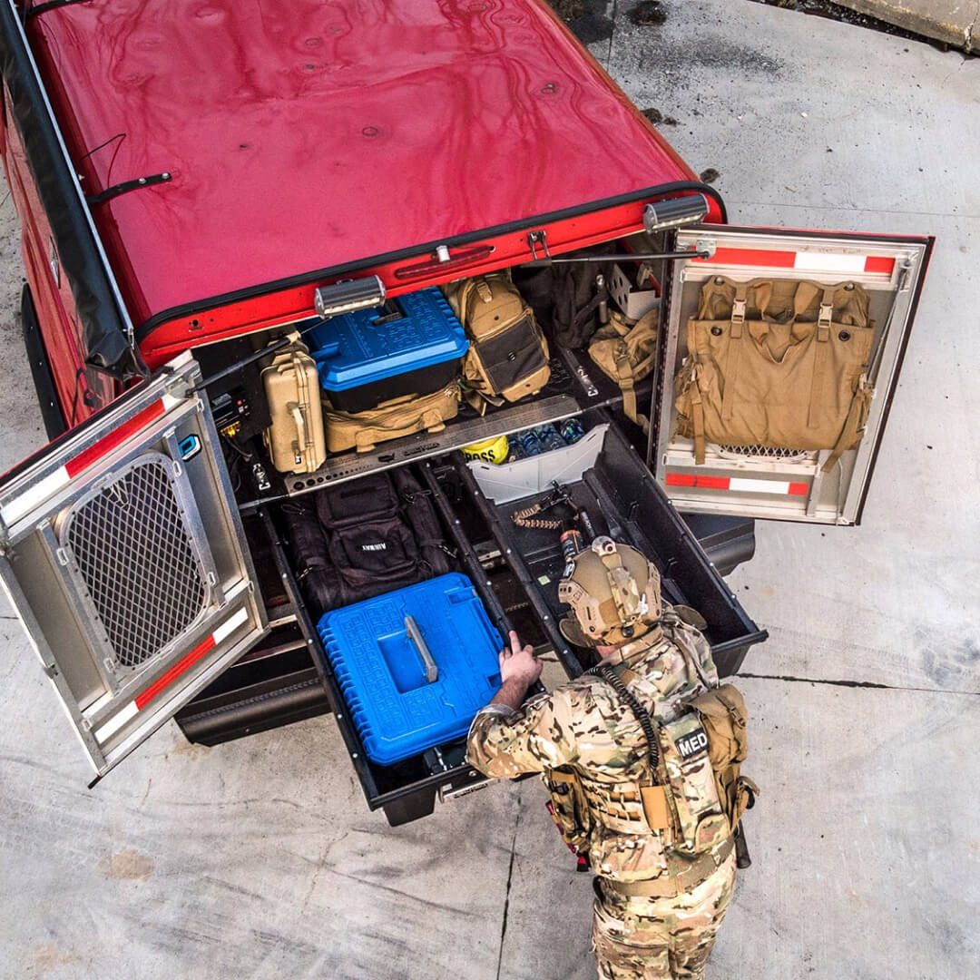 Overhead view of a soldier accessing his weapons and other tactical gear out of his Drawer System
