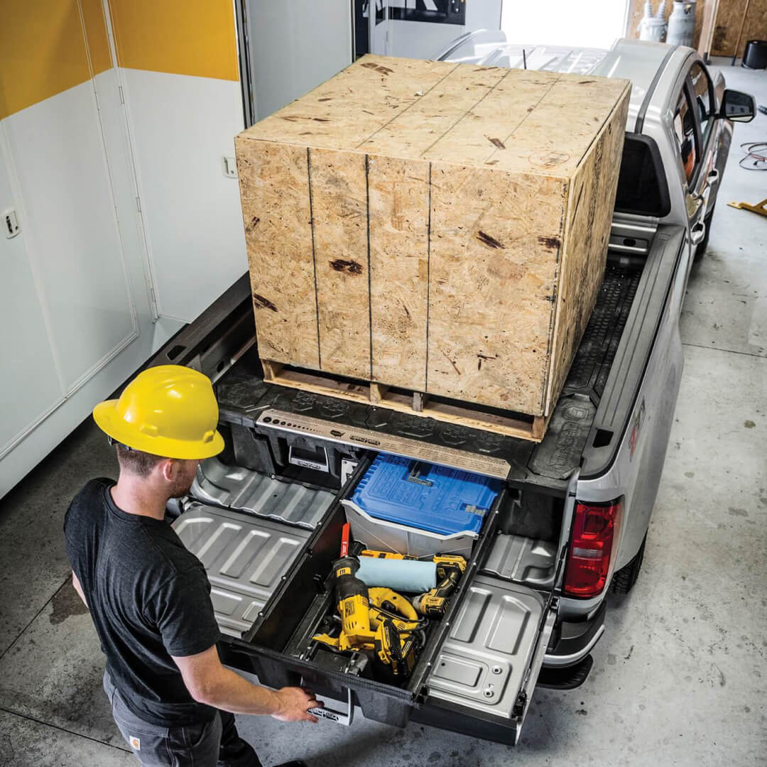 Large pallet of wood on top of a Drawer System and construction worker opening the drawer to access gear