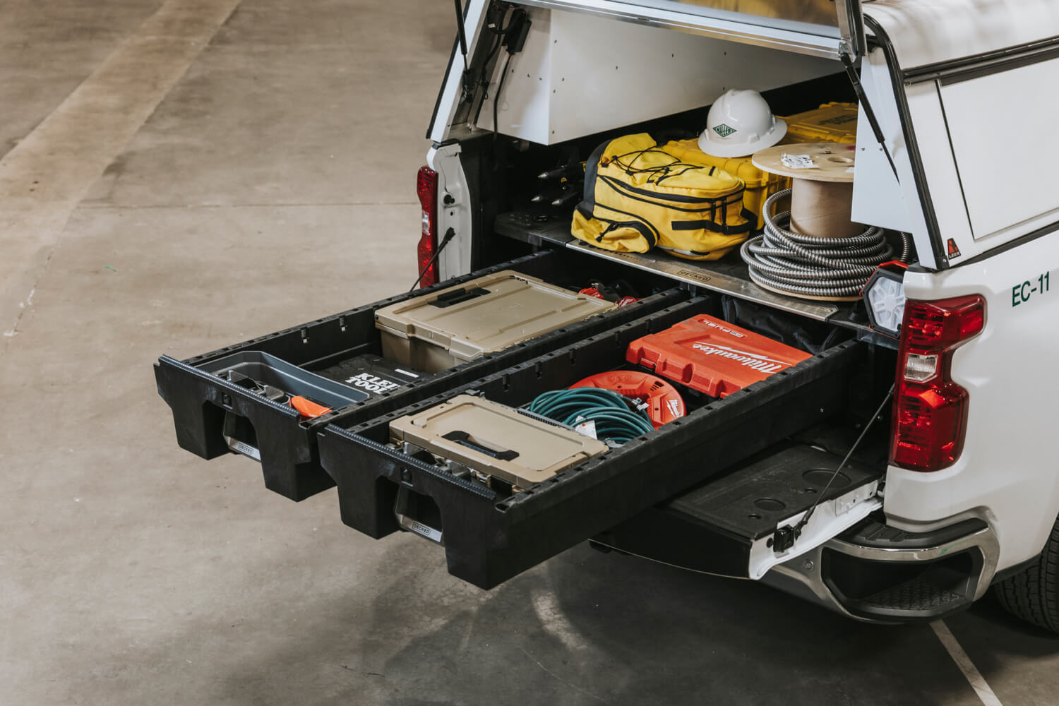 A drawer system in a fleet vehicle full of tools and d-co cases.