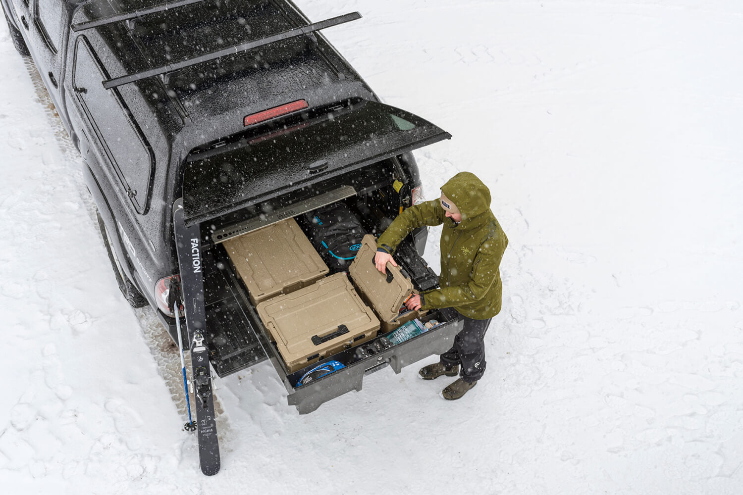 A woman with in her ski clothes pulling gear out of her drawer system.