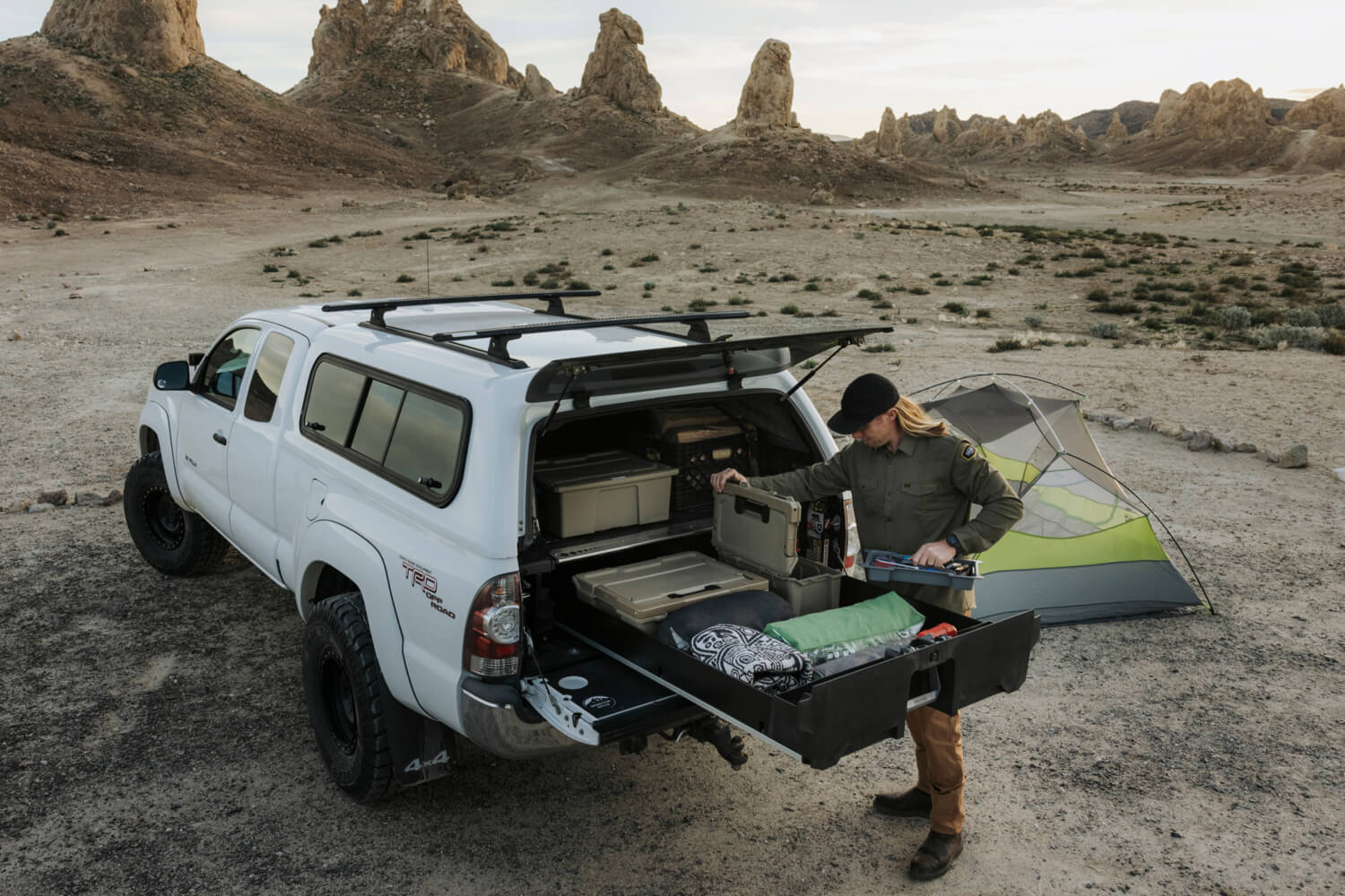 A man pulling camping gear our of his drawer system to camp in the desert.