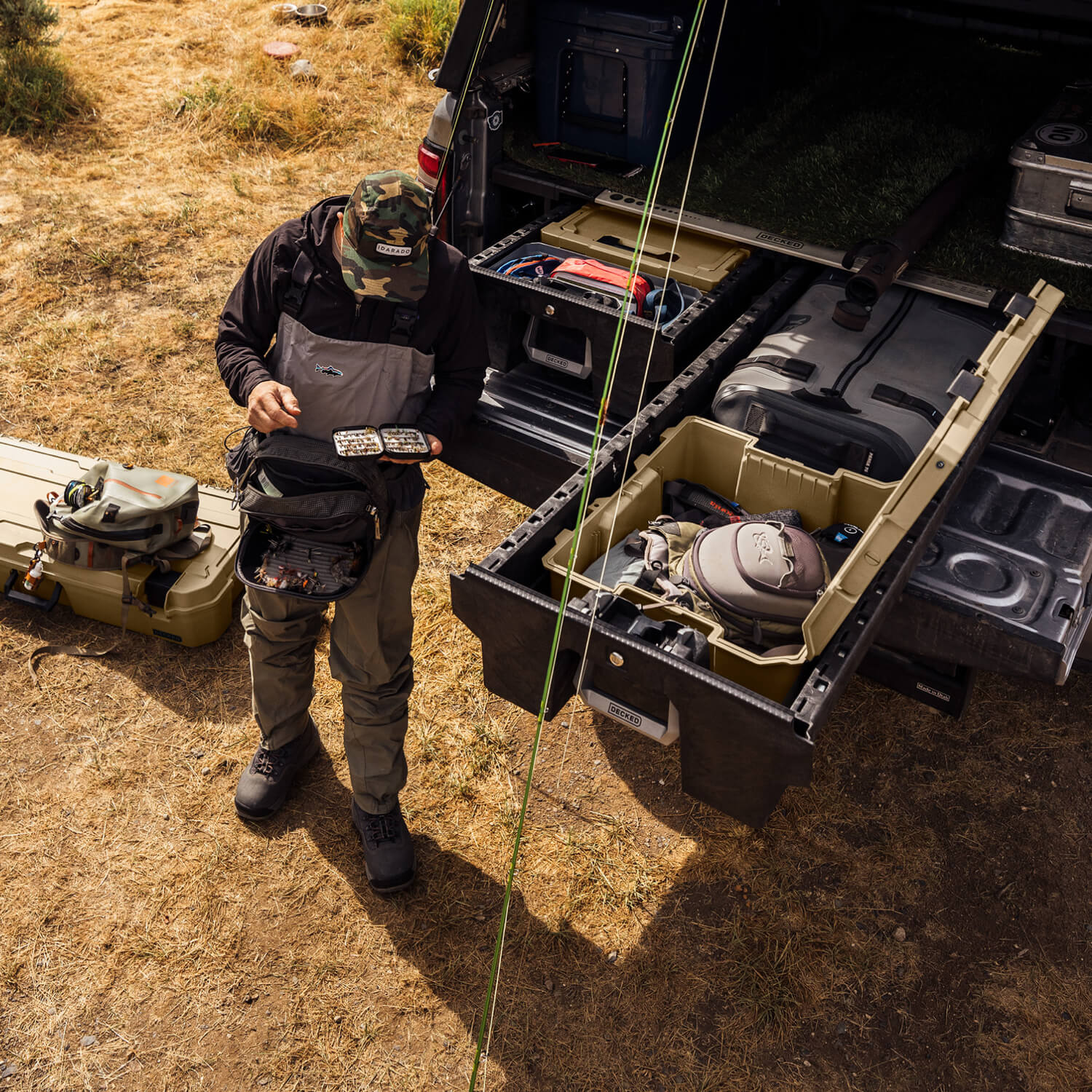 A fly fisherman looking through his fly box with the rest of his gear packed neatly in his Drawer System.