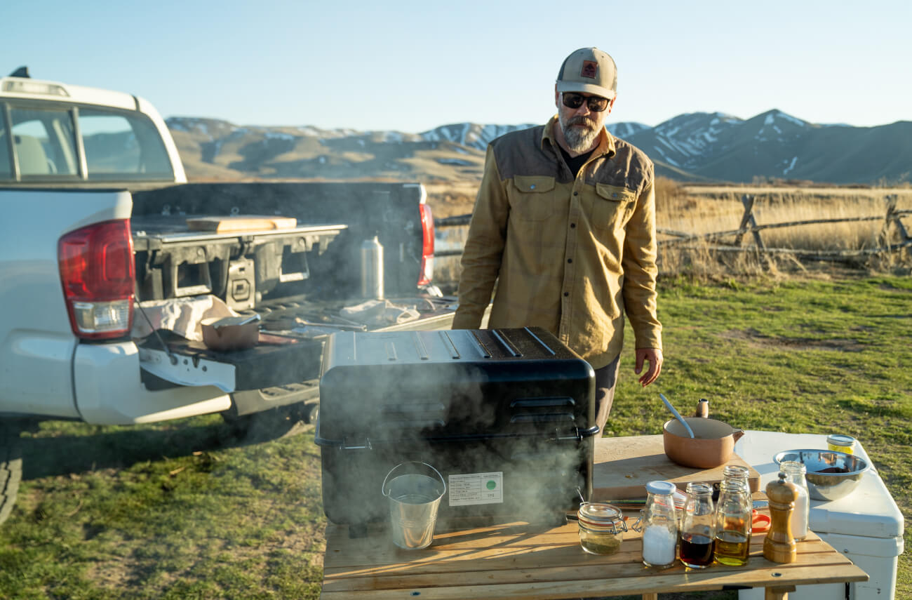 Man cooking dinner in the field while camping