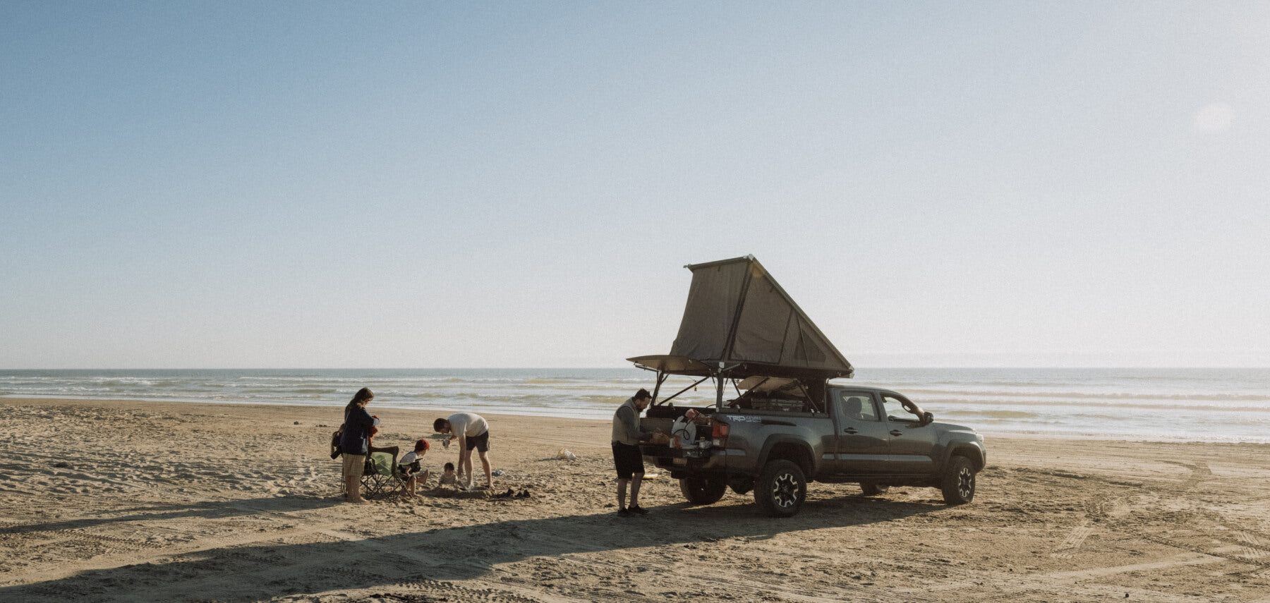family truck camping on a beach