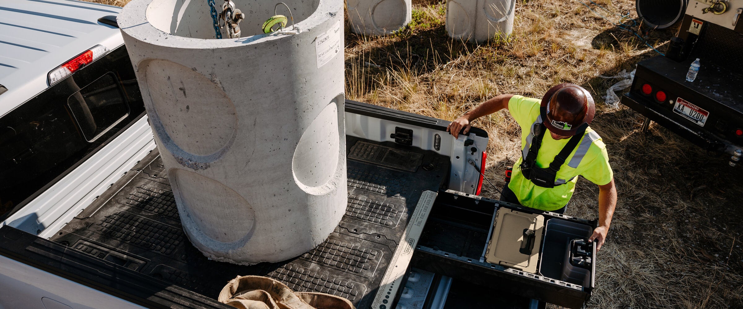 Construction worker accessing his drawer system with a large concrete cylinder on the back