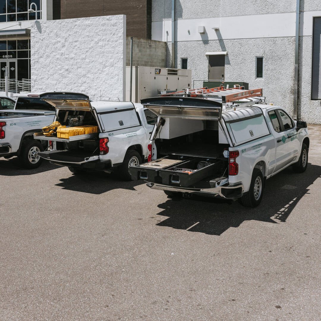 Fleet of white Chevys equipped with DECKED Drawer Systems and Cargo Glides.
