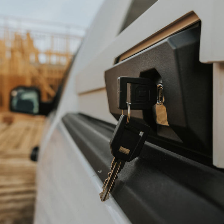 Keys inserted into a vehicle's keyhole with a blurred outdoor background