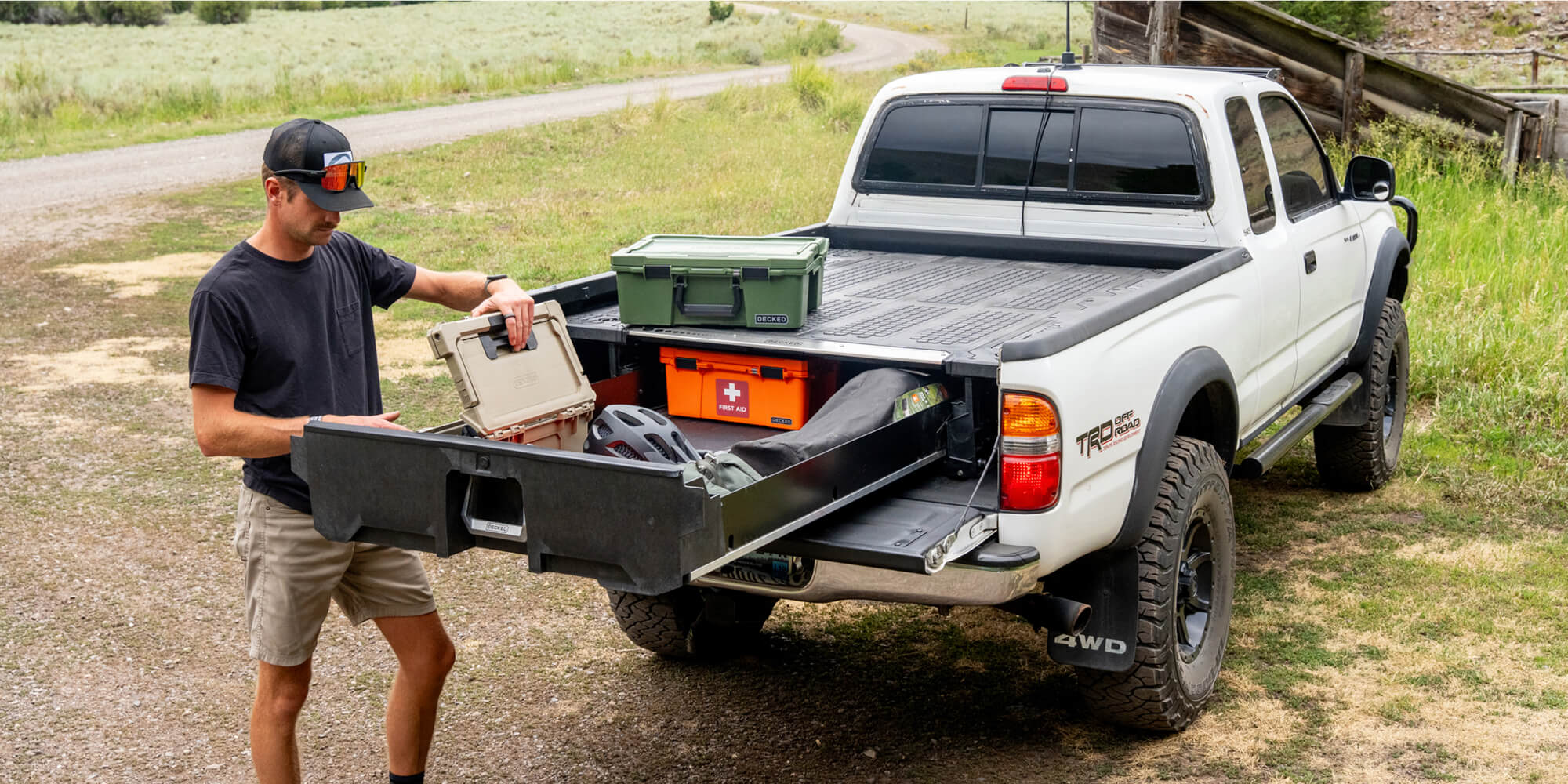 A man loading bike gear into Gen 1 Tacoma Drawer System.