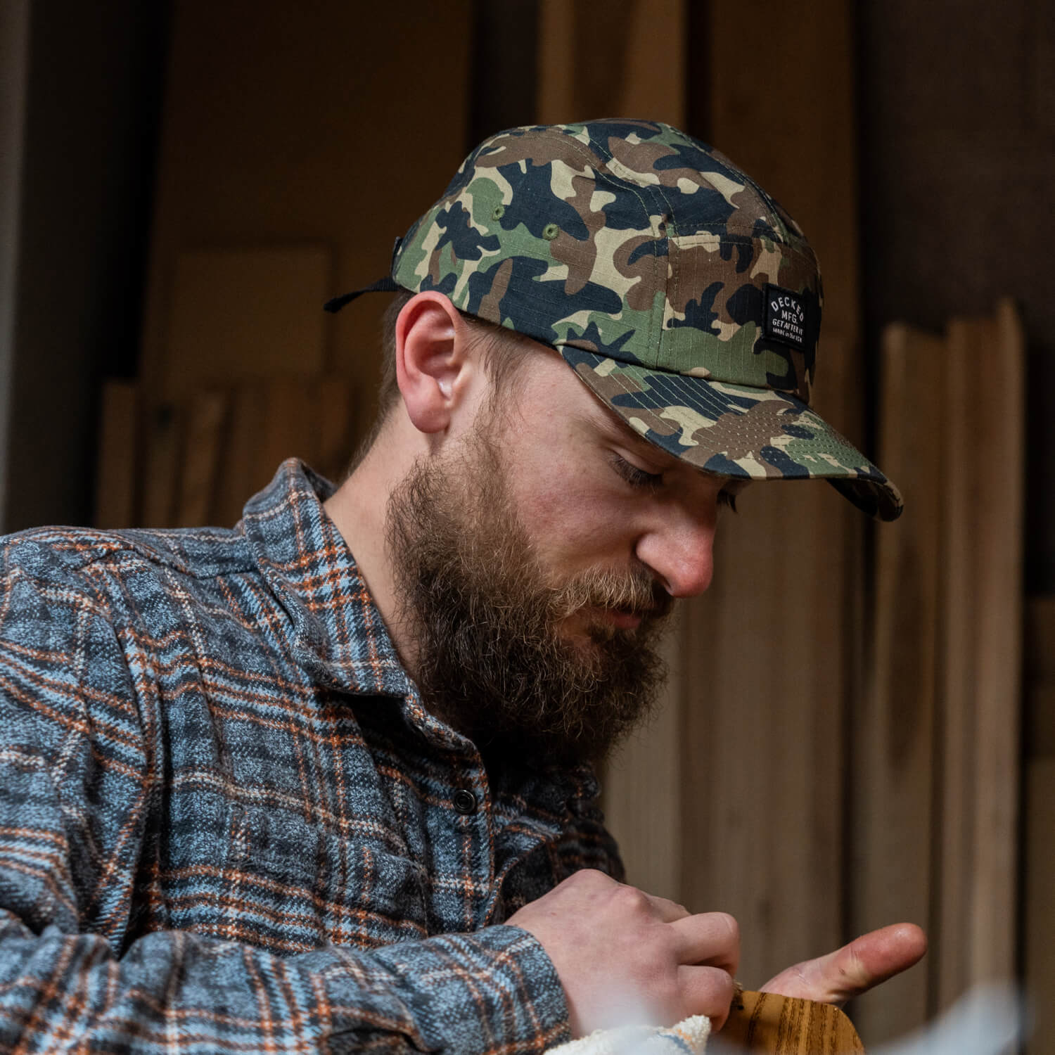 The side profile of a man in a camo "Get After It" hat.