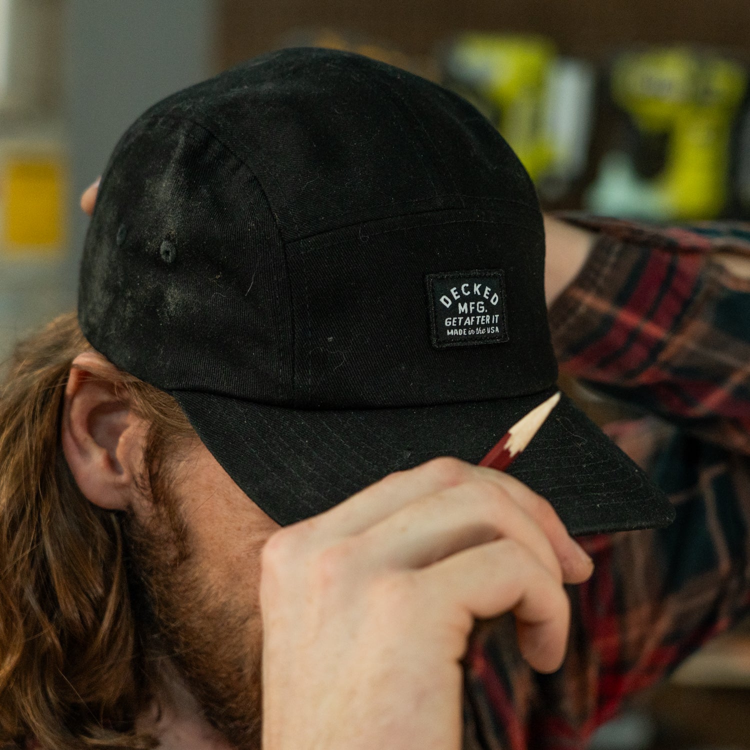 [H0113-PNL5-BLK] A man donning a black "Get After It" hat with a pencil in his hand.