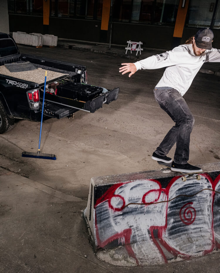 David Gravette performing a trick on his skateboard with his truck and Drawer System close by.