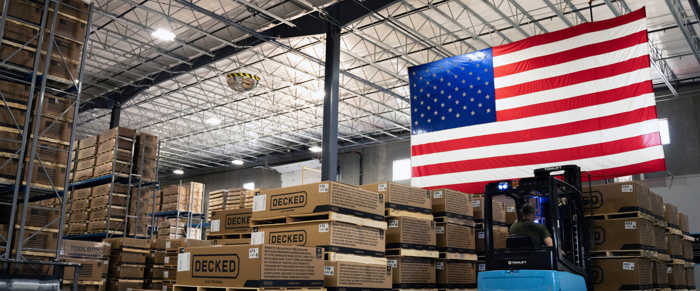 An American flag hanging over stacks of Drawer System boxes ready to ship in the DECKED Ohio Manufacturing Facility.