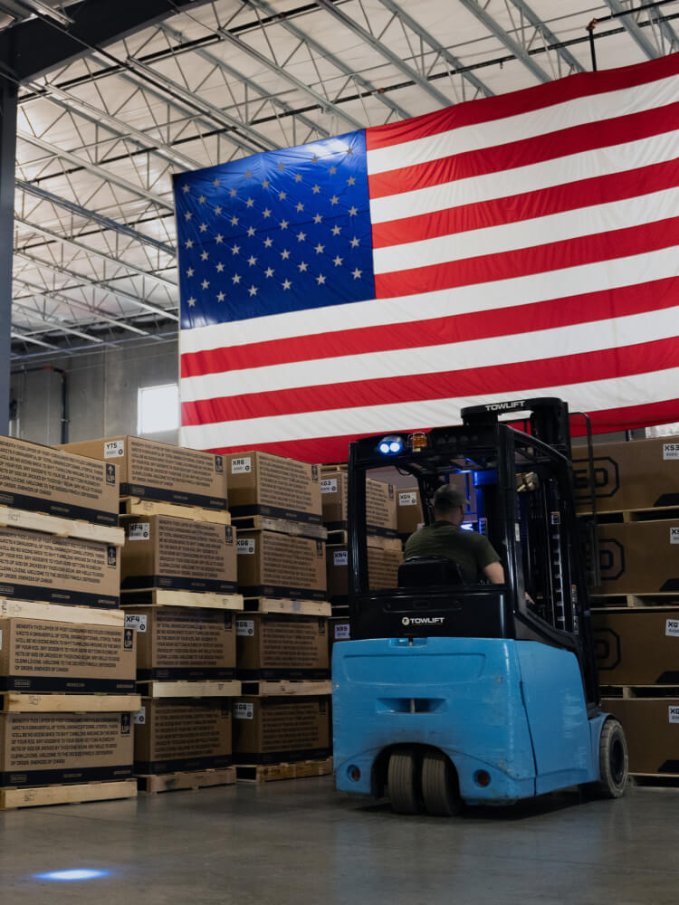 An American flag hanging over stacks of Drawer System boxes ready to ship in the DECKED Ohio Manufacturing Facility.