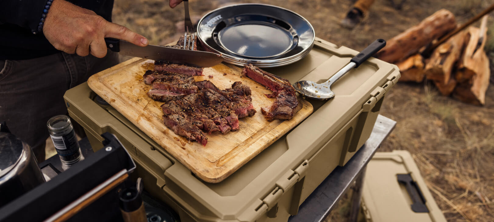 Tan Halfrack 32 being used as a platform for cutting steak while camping