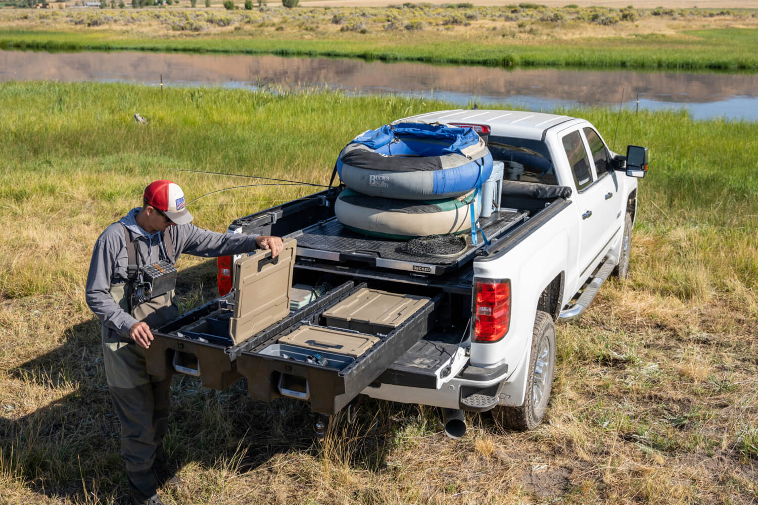 A fly fisherman well equipped with a DECKED Drawer System, CargoGlide, and D-co cases that organize all of his gear.