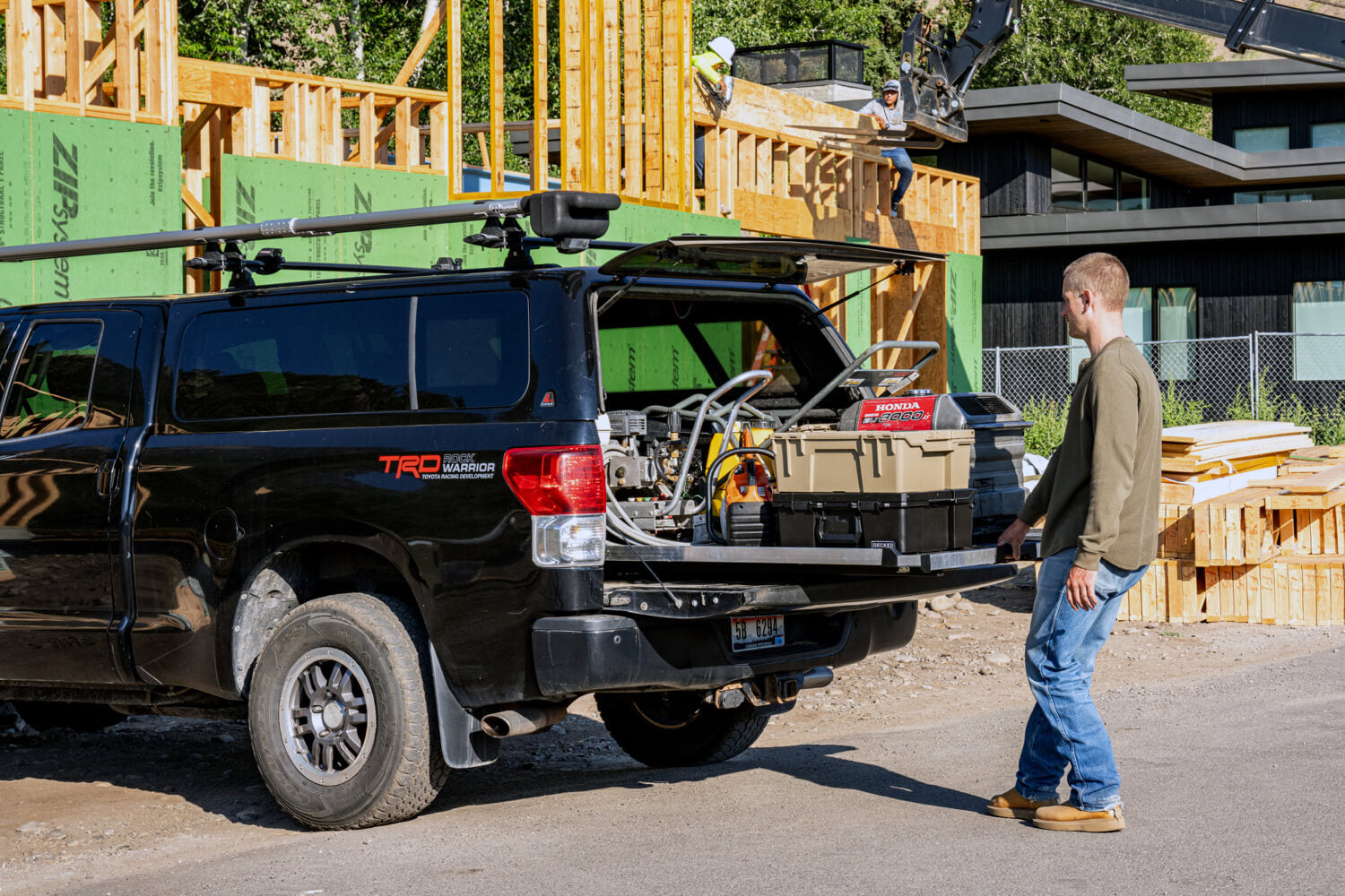 A man at a construction site retrieving essential tools from the bed of his truck via his CargoGlide.