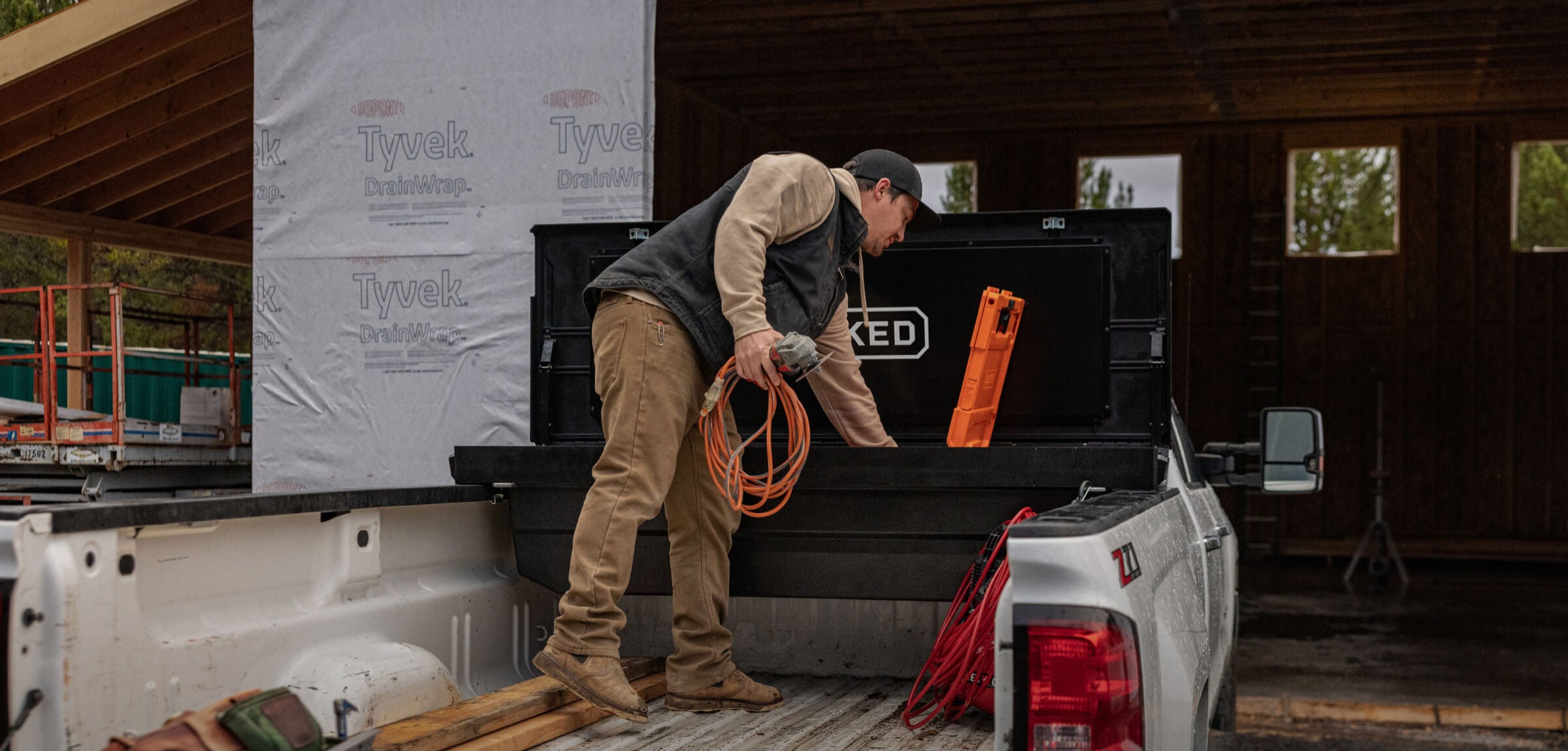 A man retrieving tools from his truck's tool box.