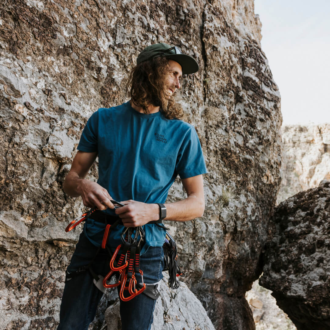 DECKED team member, Jackson Marvell, prepping for a climb up a steep rock face.