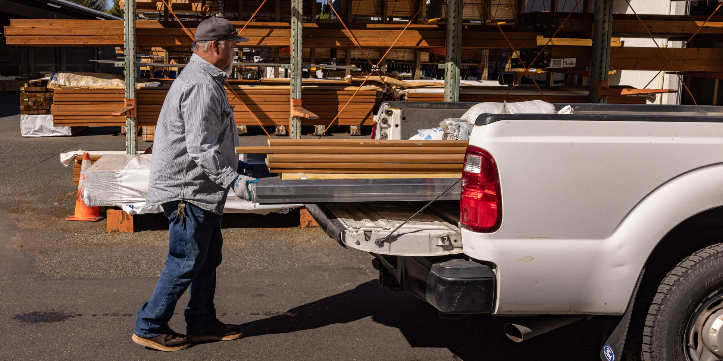 A contractor effortlessly sliding his Cargo Glide full of two by fours into the bed of his truck.